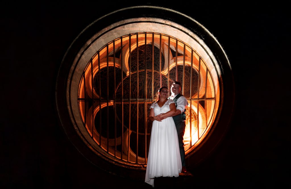 Mariés sur une photo créative au flash éclairant une rosace